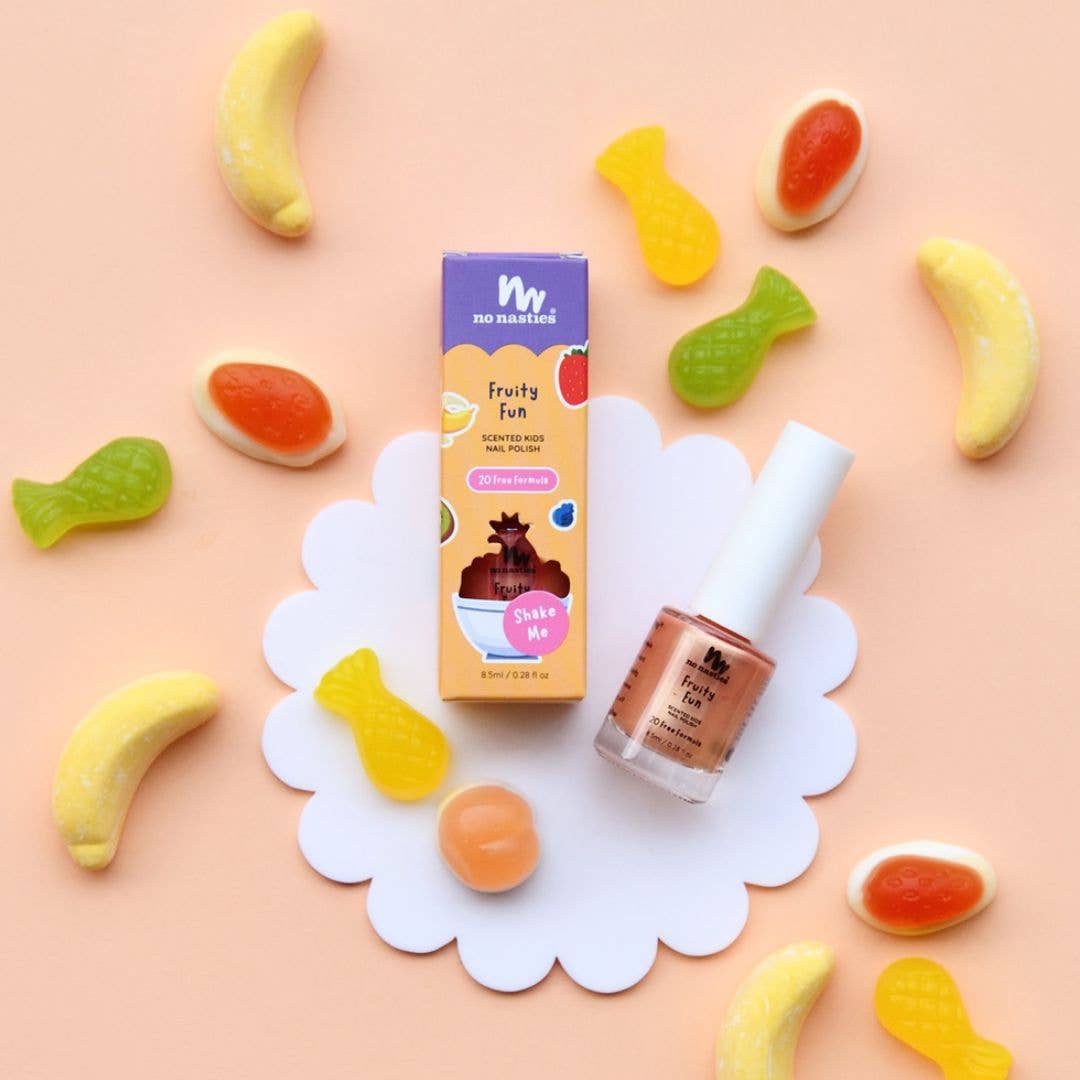 Fruity-themed nail polish set with gummy candy decorations on a pink background
