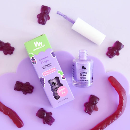 Gummy grape-themed nail polish set with packaging and gummy bear candies on a light purple background