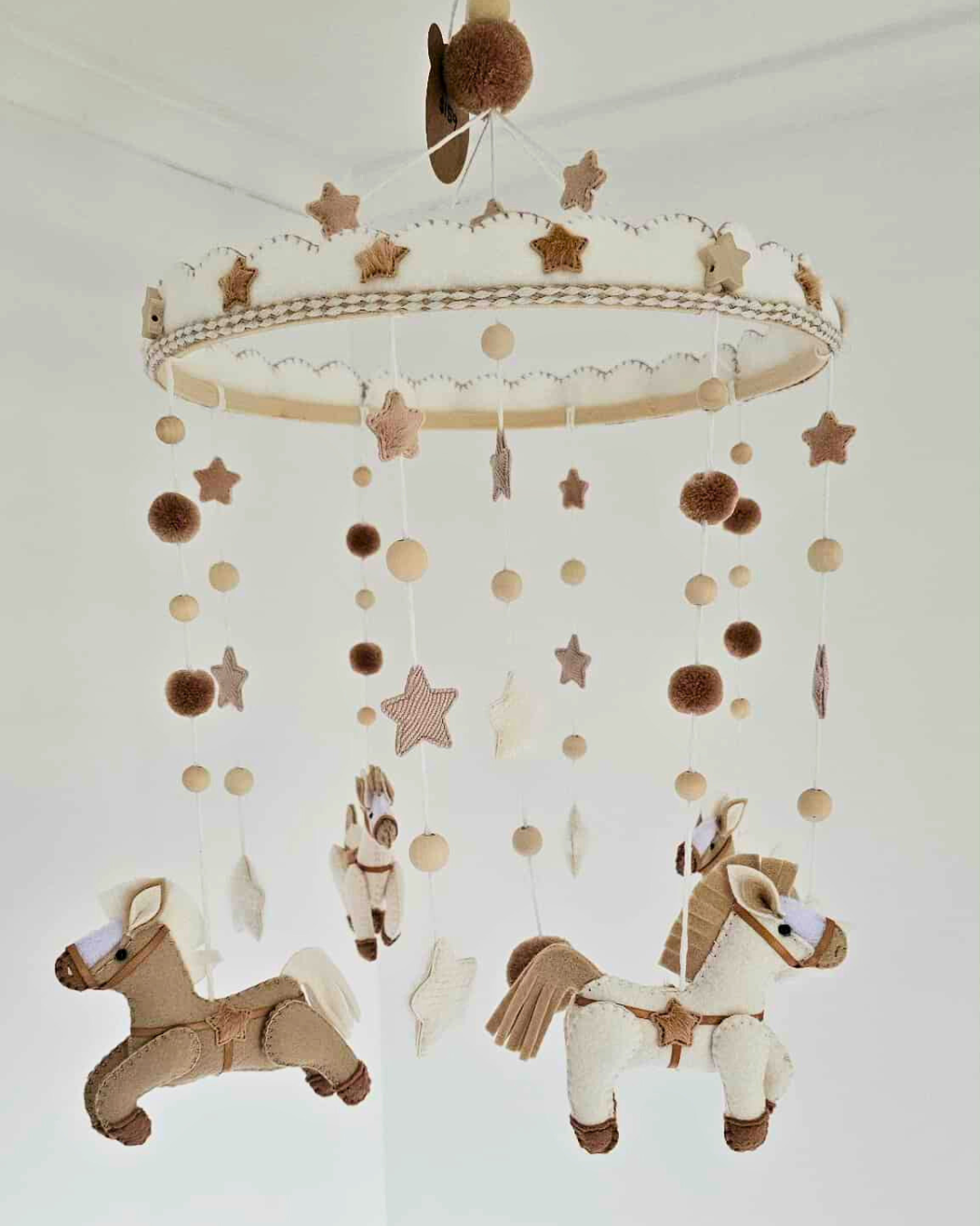 Baby mobile with star and polka dot design with horses on a white background