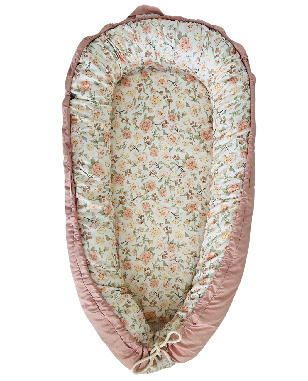 Floral-patterned baby nest with pink border on a white background