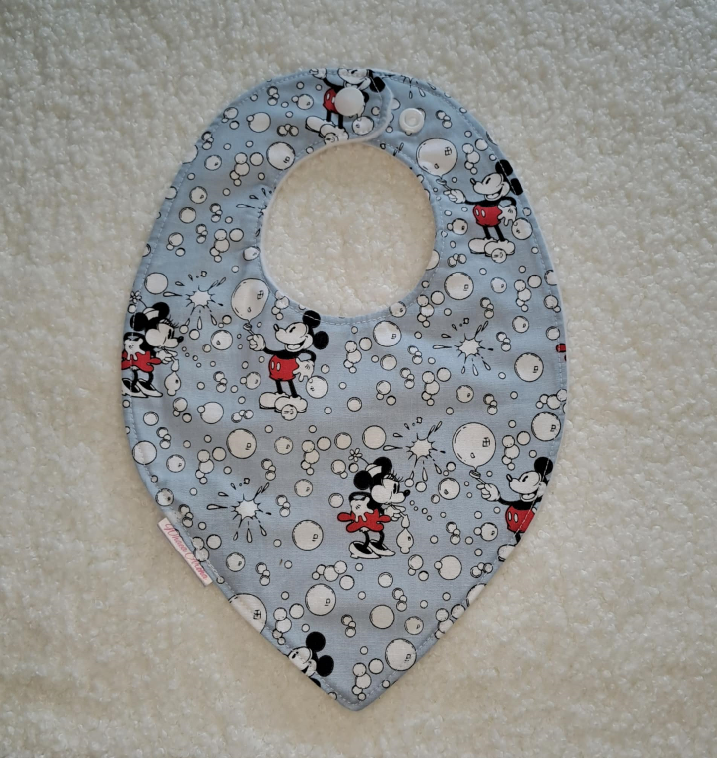 Baby bib with Mickey Mouse design on a light blue background