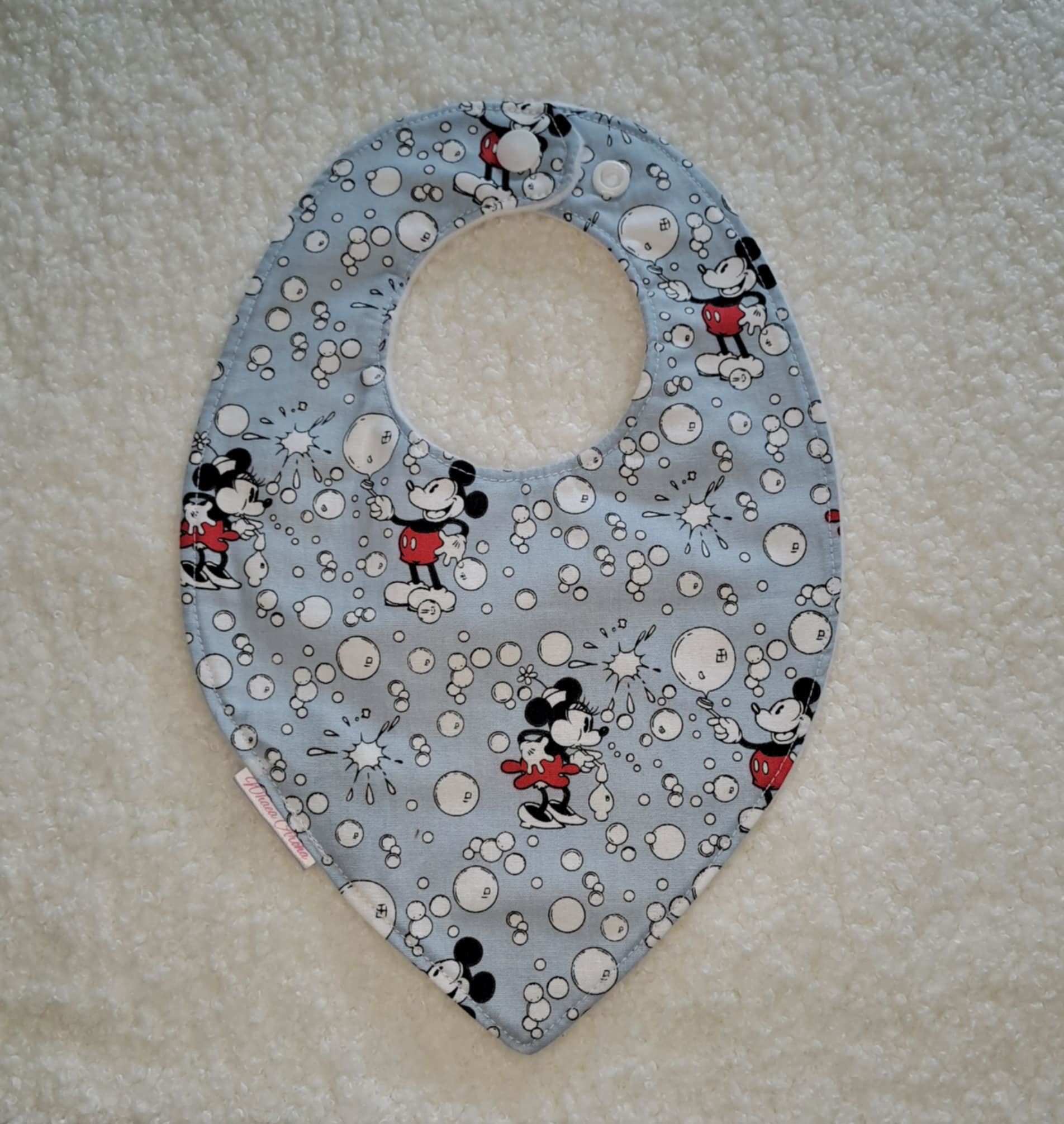 Baby bib with Mickey Mouse design on a light blue background