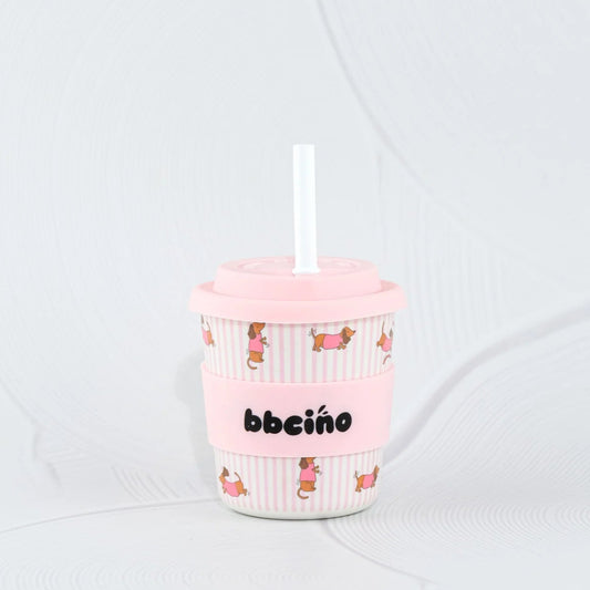 Pink tumbler with DOG design and straw on a white background